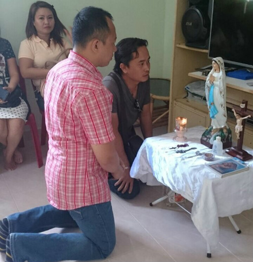 A worshipper kneels before the figurine of the ‘weeping’ Virgin Mary, at the owner’s house in Kampung Mahandoi, near Penampang, Sabah.