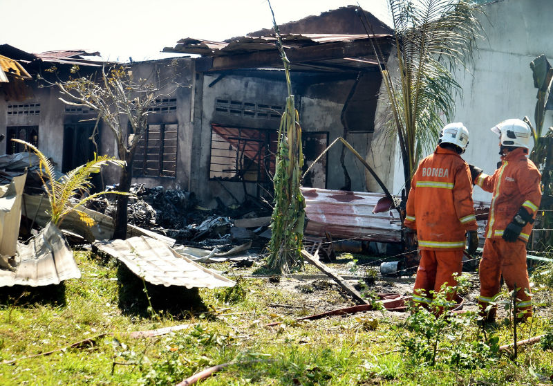 Firefighters carry out investigations in a house that was destroyed by the KT-1B aircraft of Jupiter Aerobatic Team Indonesia that crashed on March 15, 2015 at Kampong Glam Haipo, Langkawi, during practice in conjunction with LIMA 2015. u00e2u20acu201d Bernama pic