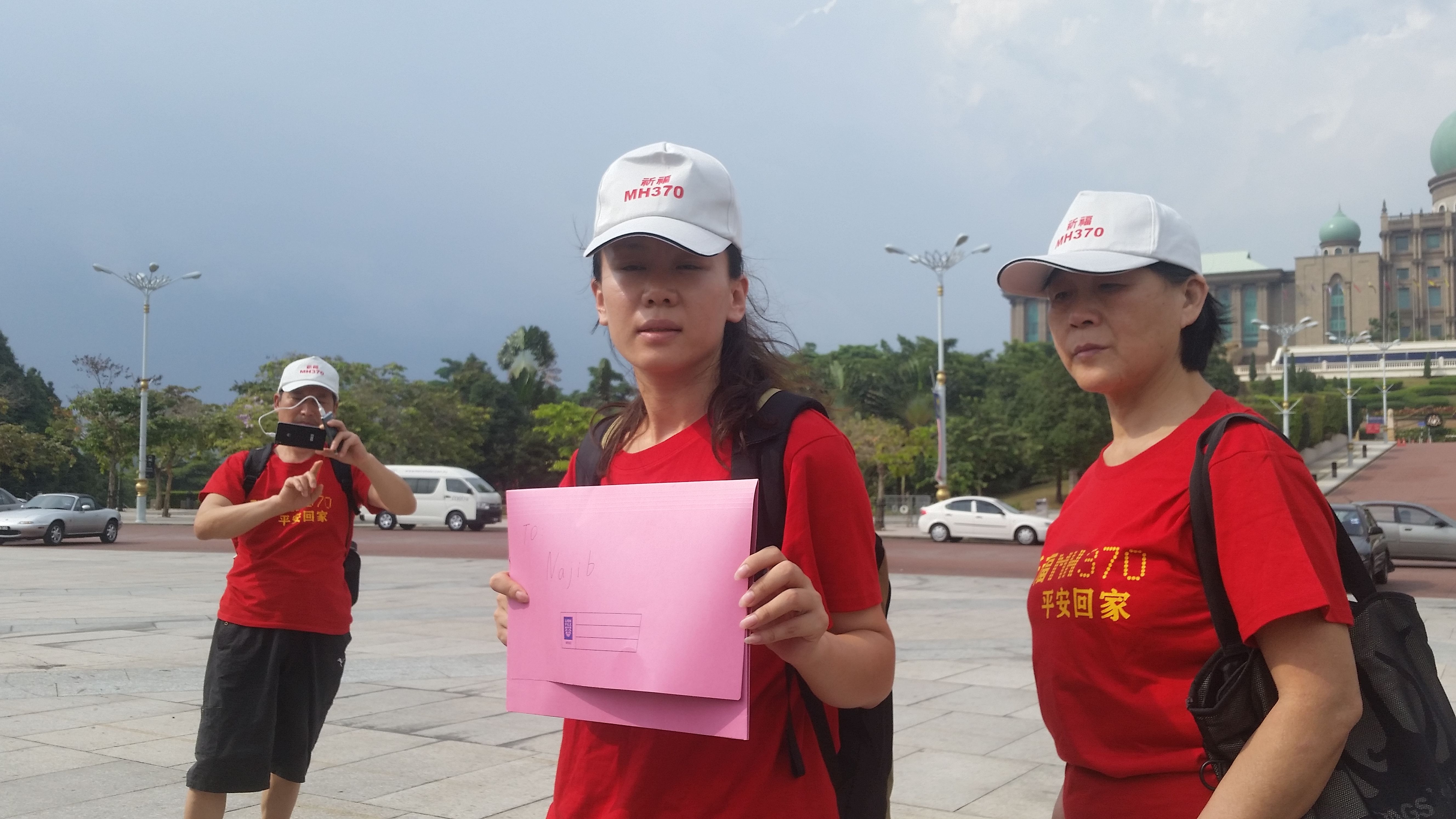 Kelly Wen (holding pink file) at Putrajaya with families of Chinese passengers aboard missing Malaysia Airlines flight MH370 mourn the loss of their loved ones at a gathering, February 18, 2015.