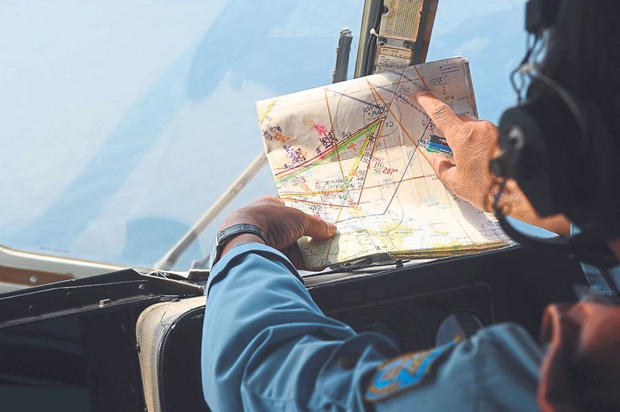 A Vietnamese Air Force personnel checks a map during a search flight about 200km off Phu Quoc Island on March 11 last year. u00e2u20acu201d Picture by AFP