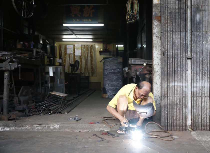 A man solders bike parts at his workshop in Kuala Lumpur March 3, 2015. On April 1, a new six percent goods and services tax will come into effect in Malaysia. u00e2u20acu201d Reuters pic