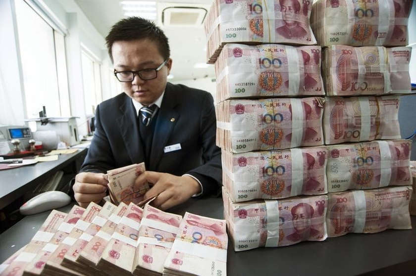 A clerk counts Chinese 100 yuan banknotes at a branch of China Construction Bank in Nantong, Jiangsu province December 2, 2014. u00e2u20acu201d Reuters pic