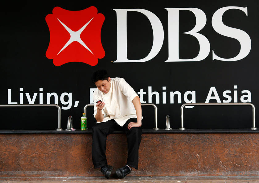 A man takes a break outside a branch of DBS Group Holdings in Singapore August 5, 2014. Some banks are adopting stricter lending criteria for China's state-owned enterprises. u00e2u20acu201d Reuters pic