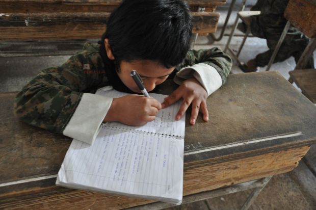 A picture released by the Abdullah Azzam academy shows an Islamic State child recruit studying in class. u00e2u20acu2022 Picture taken from azzammedia.com