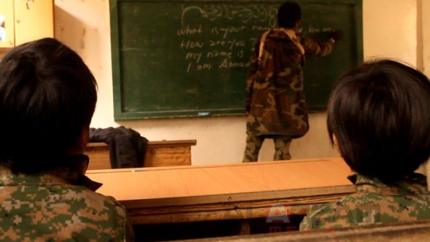 A teacher is seen teaching Islamic State child recruits in this picture released by the Abdullah Azzam academy.