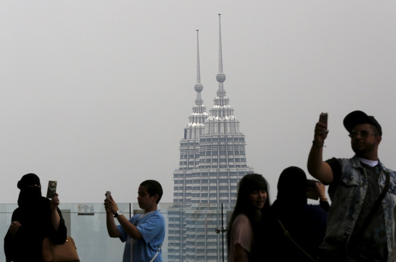 Visitors take u00e2u20acu02dcselfiesu00e2u20acu2122 in front of Malaysiau00e2u20acu2122s landmark Petronas Towers in Kuala Lumpur, March 19, 2015. u00e2u20acu201d Reuters pic