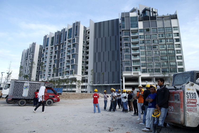 Workers wait to start work outside a soon-to-be-completed condominium project at Kota Iskandar in Johor, February 4, 2015. u00e2u20acu201d Reuters pic