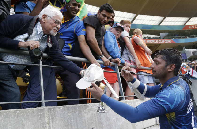 Sri Lanka's Kumar Sangakkara (right) signs autographs after beating England in their Cricket World Cup match in Wellington, March 1, 2015. u00e2u20acu201d Reuters pic