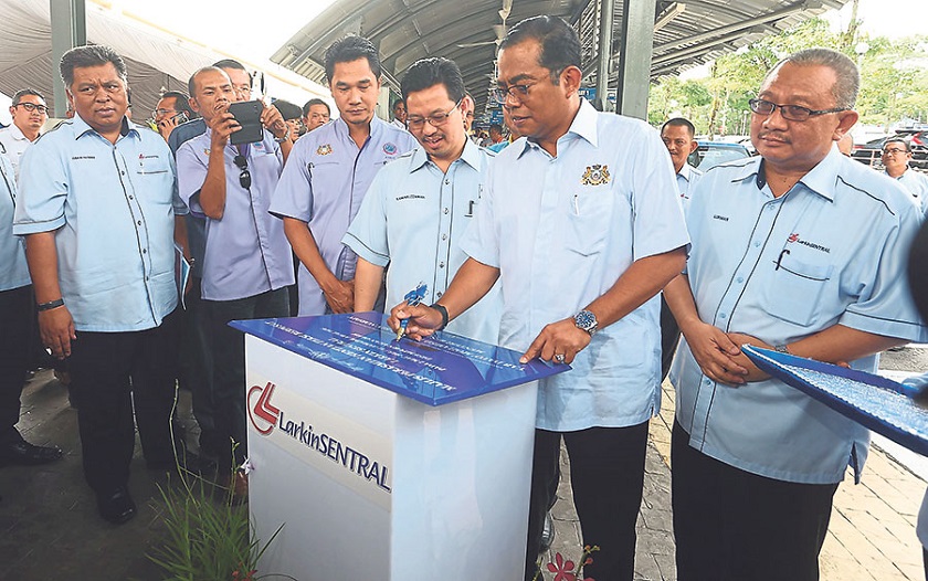 Johor Corporation chief executive Datuk Kamaruzzaman Abu Kassim sign a plaque after launching the new taxi terminal at Larkin Sentral yesterday. u00e2u20acu201d file pic 