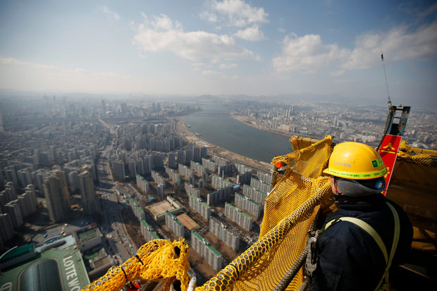 A construction worker looks out from 99th floor of Lotte World Tower, which is currently under construction, in Seoul March 4, 2015. u00e2u20acu201d Reuters pic