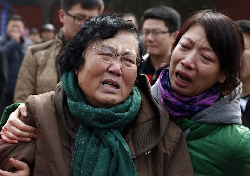 Wang Guohui (left), mother of Li Zhi, a passenger of the missing Malaysia Airlines flight MH370, cries with daughter-in-law Catherine Gang during a gathering of family members of the missing passengers at Yonghegong Lama Temple in Beijing March 8, 2015.u00c2u00a0