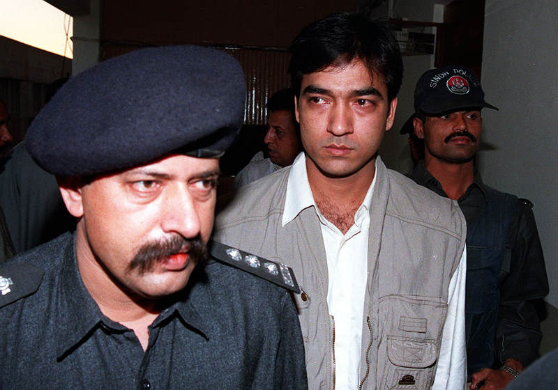 Pakistani policemen escort Saulat Mirza (centre) in Karachi December 11, 2014. u00e2u20acu201d AFP pic