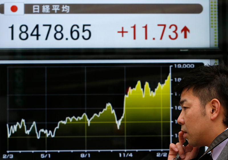 A pedestrian walks past an electronic board showing the Japan's Nikkei average and recent fluctuations outside a brokerage in Tokyo February 24, 2015. Asia stocks are generally on the rise. u00e2u20acu201d Reuters pic