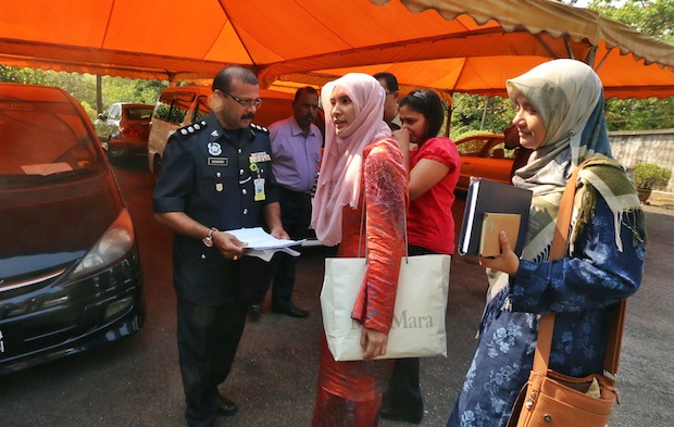 Nurul Izzah Anwar retrieving the hardcopy of the Parliament speech from her house before being escorted back to Dang Wangi Police Station, Kuala Lumpur, March 17, 2015. u00e2u20acu201d Picture by Saw Siow Feng