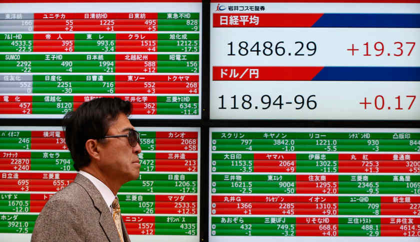 A pedestrian walks past an electronic board showing Japan's Nikkei average and exchange rates in Tokyo February 24, 2015. Asian shares were firmer today (March 3, 2015). u00e2u20acu201d Reuters pic 