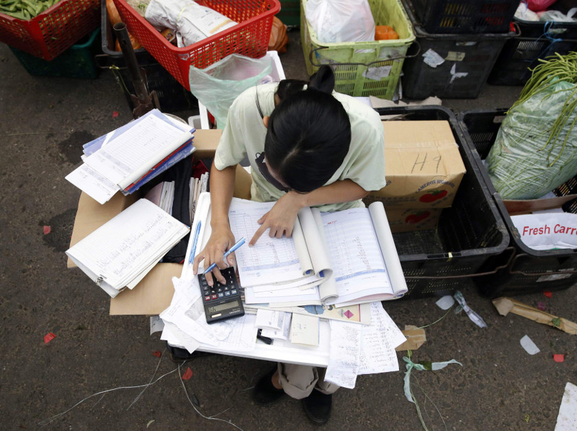 A trader completes paperwork at a wet market in Kuala Lumpur March 3, 2015. On April 1, a new six percent goods and services tax will come into effect in Malaysia. u00e2u20acu201d Reuters pic