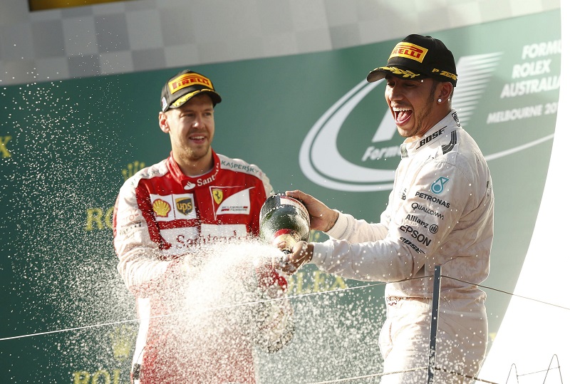 Third placed Ferrari Formula One driver Sebastian Vettel of Germany (left) and race winner Mercedes Formula One driver Lewis Hamilton of Britain celebrate on the podium after the Australian F1 Grand Prix at the Albert Park circuit in Melbourne, March 15, 