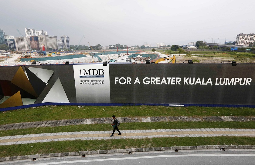 A man walks past a 1Malaysia Development Berhad (1MDB) billboard at the funds flagship Tun Razak Exchange development in Kuala Lumpur, March 3, 2015. u00e2u20acu201d Reuters pic