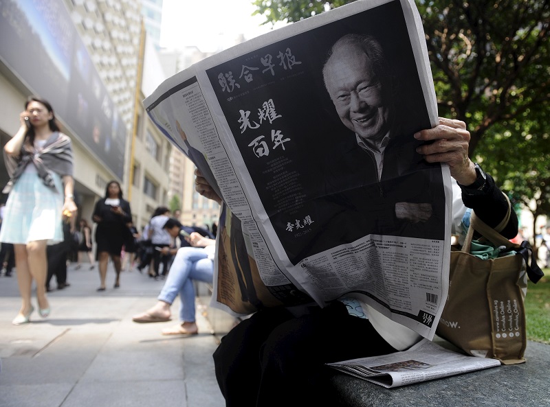 A woman reads a newspaper bearing the image of Singaporeu00e2u20acu2122s former prime minister Lee Kuan Yew, at Raffles Place in Singapore, March 23, 2015. u00e2u20acu201d Reuters pic