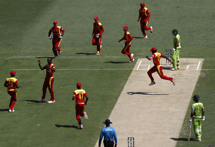 Zimbabwe's Tendai Chatar (2nd left) celebrates with team mates after dismissing Pakistan's Nasir Jamshed (right) for one run during their Cricket World Cup match at the Gabba in Brisbane March 1, 2015. — Reuters pic