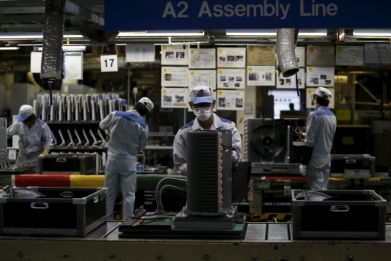 An employee of Daikin Industries Ltd works the production line of outdoor air conditioning units at the companyu00e2u20acu2122s Kusatsu factory in Shiga prefecture, western Japan, April 5, 2015. u00e2u20acu201d Reuters pic