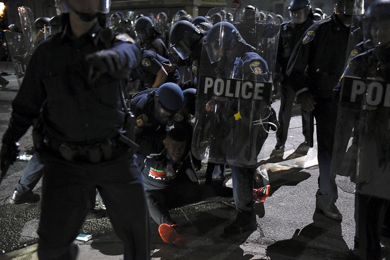 Law enforcement officers detain a demonstrator on Gilmore Avenue near Baltimore Police Department Western District during a protest against the death of Freddie Gray in police custody, in Baltimore April 25, 2015. u00e2u20acu201d Reuters