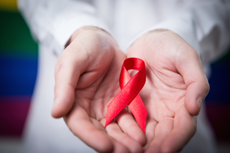 A man holds an HIV/AIDS awareness ribbon. u00e2u20acu201d AFP-Relaxnews pic