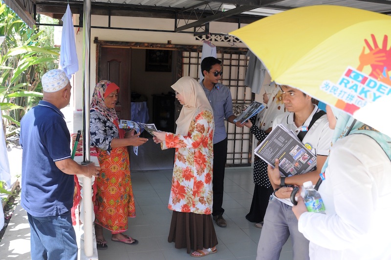 Nurul Iman Anuar hands out flyers to Permatang Pauh residents.
