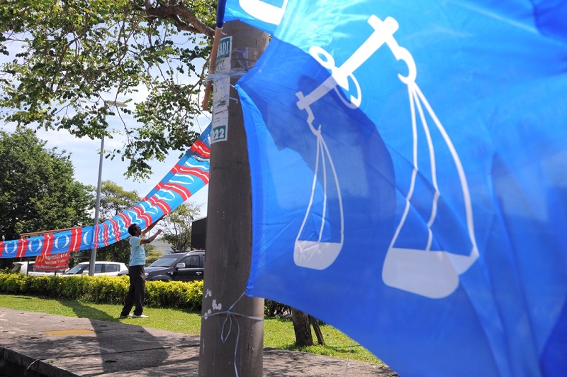 A man fixes PKR party flags along a roadside at Jalan Permatang Pauh in Permatang Pauh, Penang, April 26, 2015. u00e2u20acu201d Picture by K.E. Ooi