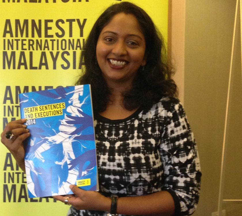 Amnesty International Malaysia executive director Shamini Darshni poses with the 2014 report on death penalty. u00e2u20acu201d Picture by Melissa Chi