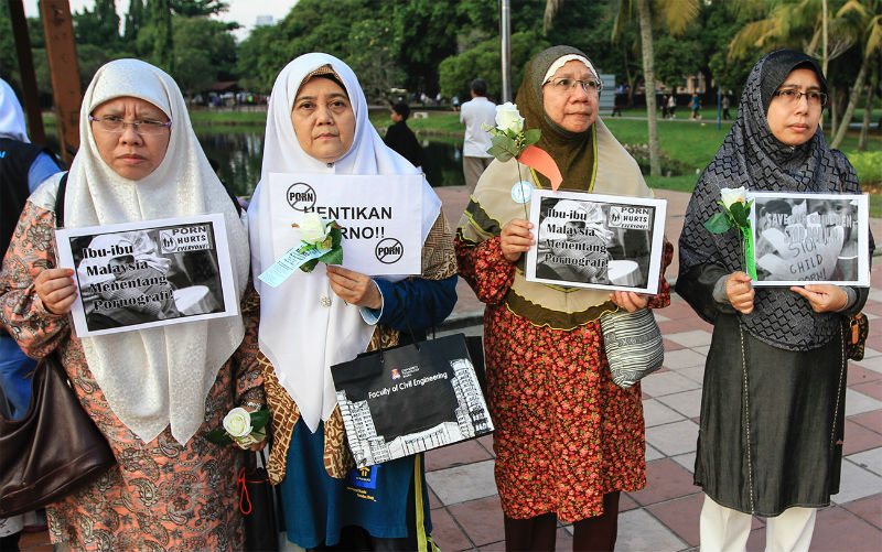 Wanita Ikram Wilayah Persekutuan members hold placards and flowers during the launch of Mothers against Pornography campaign at Taman Tasik Titiwangsa, Kuala Lumpur, May 10, 2015. u00e2u20acu201d Picture by Yusof Mat Isa