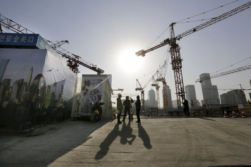 Workers chat outside a construction site in Beijing's central business district, in this December 29, 2014 file photo. China's economy is said to be looking gloomy. u00e2u20acu201d Reuters pic