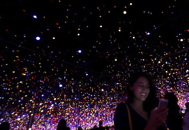A tourist uses her phone inside the Infinity Mirrored Room by Yayoi Kusama from the Seeing Through Light selections from the Guggenheim Abu Dhabi collection at the Manarat Al Saadiyat Gallery in Abu Dhabi November 27, 2014.u00c2u00a0u00e2u20acu201d Reuters pic