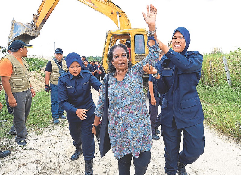 Police arrest PSM national deputy chairman M. Sarasvathy during a scuffle between Parti Sosialis Malaysia members, the farmers, and MB Inc workers, April 27, 2015. u00e2u20acu201d Picture by Marcus Pheong  