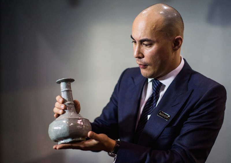 Deputy Chairman for Sothebyu00e2u20acu2122s Asia and the International Head of Chinese Ceramics and Works of Art, Nicolas Chow, displays a u00e2u20acu02dcGuanu00e2u20acu2122 octagonal vase from Chinau00e2u20acu2122s Southern Song Dynasty (1127-1279 AD), after its sale for nearly US$15 million, at an au