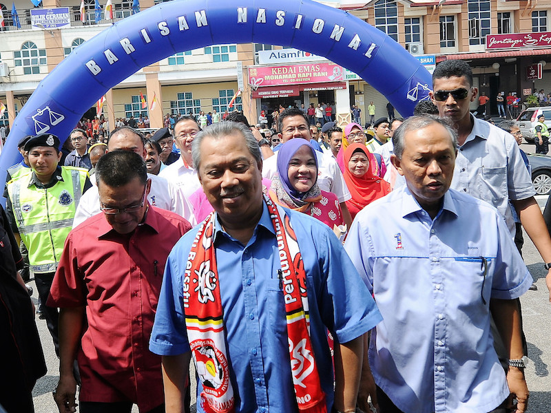 Tan Sri Muhyiddin Yassin and Datuk Hasan Arifin walk towards the Umno division office in Rompin April 18, 2015. u00e2u20acu201d Bernama pic
