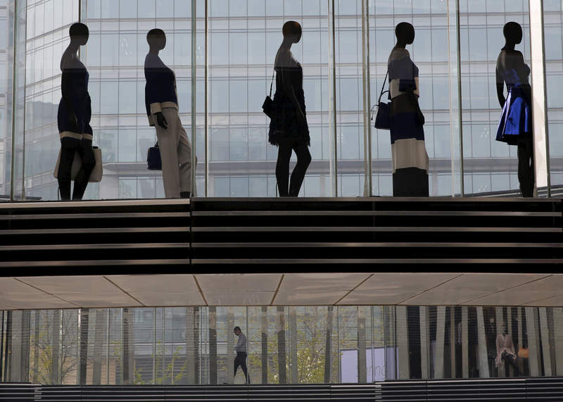 A man walking under mannequins at a shopping mall in Beijing April 10, 2015. The World Bank sees China's economy likely to slow to 7.1 per cent in 2015. u00e2u20acu201d Reuters pic 