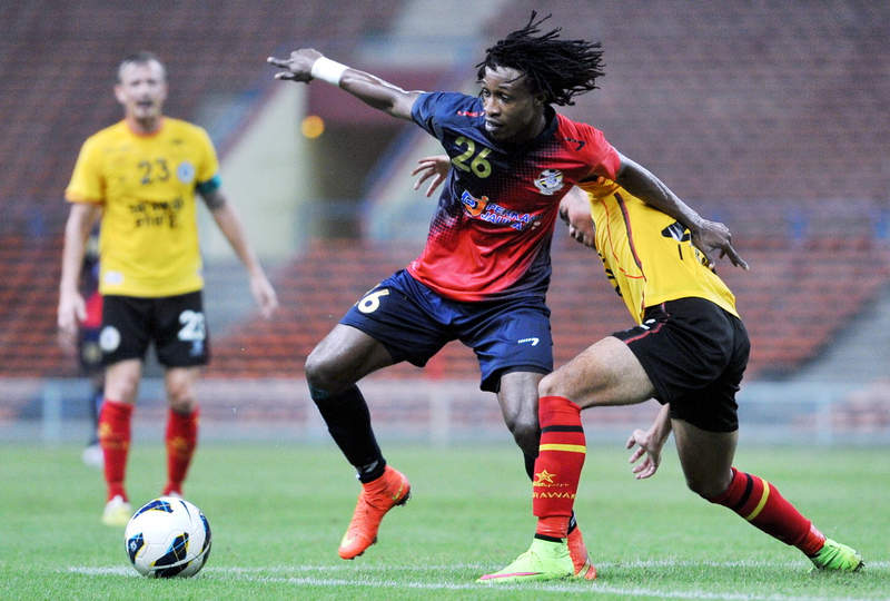 PDRM's Mohamadou Sumareh (centre) trying to shake off Sarawak's Mazwandi Zakeria (right) in a Super League match at Shah Alam April 3, 2015. u00e2u20acu201d  Bernama pic