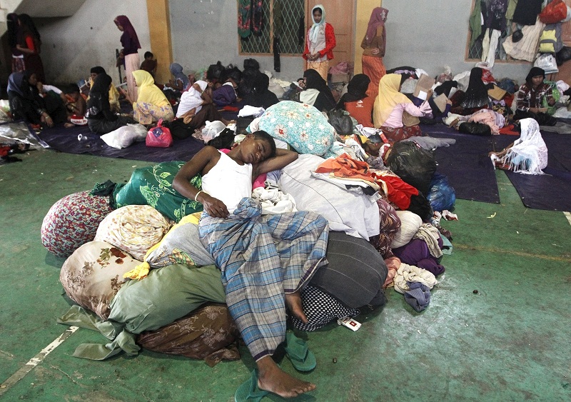A migrant, believed to be Rohingya, sleeps on a pile of donated clothes inside a shelter where he is staying in since being rescued along with hundreds of others on Sunday from boats in Lhoksukon, Indonesia's Aceh Province May 12, 2015. u00e2u20acu201d Reuters pic
