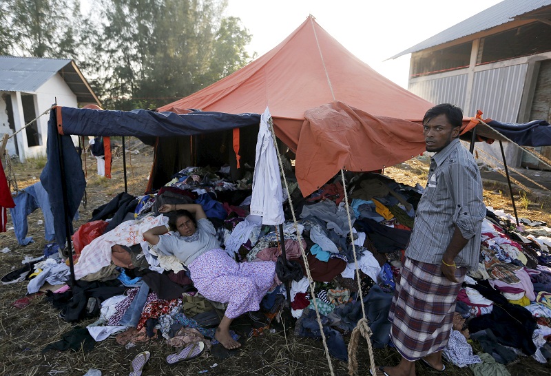 A Rohingya migrant woman, who recently arrived in Indonesia by boat, lies on a pile of used donated clothes at a shelter in Kuala Langsa, in Indonesia's AcehProvince, May 19, 2015.— Reuters pic