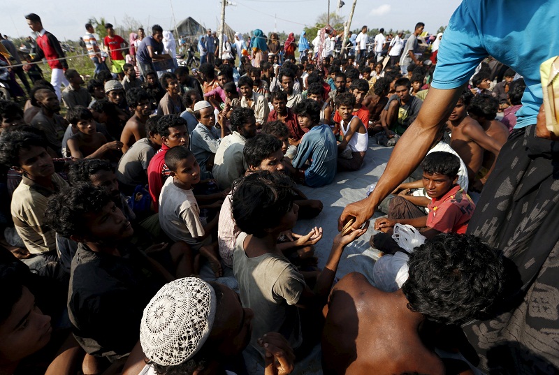 A volunteer gives biscuits to Rohingya migrants who arrived by boat at the port of Julok village in Kuta Binje, Indonesiau00e2u20acu02dcs Aceh Province, May 20, 2015. u00e2u20acu201d Reuters pic