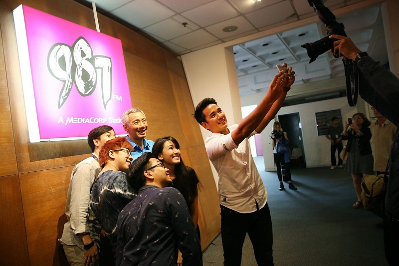 Singapore PM Lee Hsien Loong obliges for a ‘wefie’ with 987FM radio DJ Joakim Gomez and staff from 987FM shortly after recording a radio programme with Capital 95.8FM. — TODAY pic