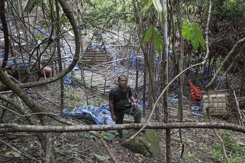 A policeman holds his gun at abandoned human trafficking camp in the jungle close the Thailand border at Bukit Wang Kelian in northern Malaysia May 26, 2015. u00e2u20acu201d Reuters pic