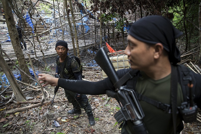 Policemen make their way through abandoned human trafficking camp in the jungle close the Thailand border at Bukit Wang Kelian in northern Malaysia May 26, 2015. u00e2u20acu201d Reuters pic