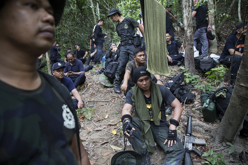 Policemen rest after hiking to the abandoned human trafficking camp in the jungle close the Thailand border at Bukit Wang Kelian in northern Malaysia May 26, 2015. — Reuters pic