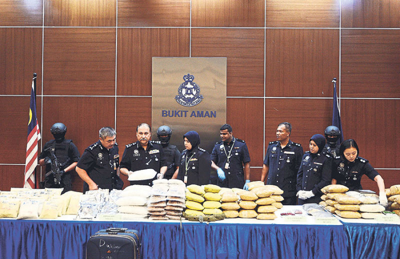 Mohd Mokhtar (third from left) says drugs amounting to RM51 million were seized from the 11 raids in Klang Valley and Penang. u00e2u20acu201d Picture by Zuraneeza Zulkifli
