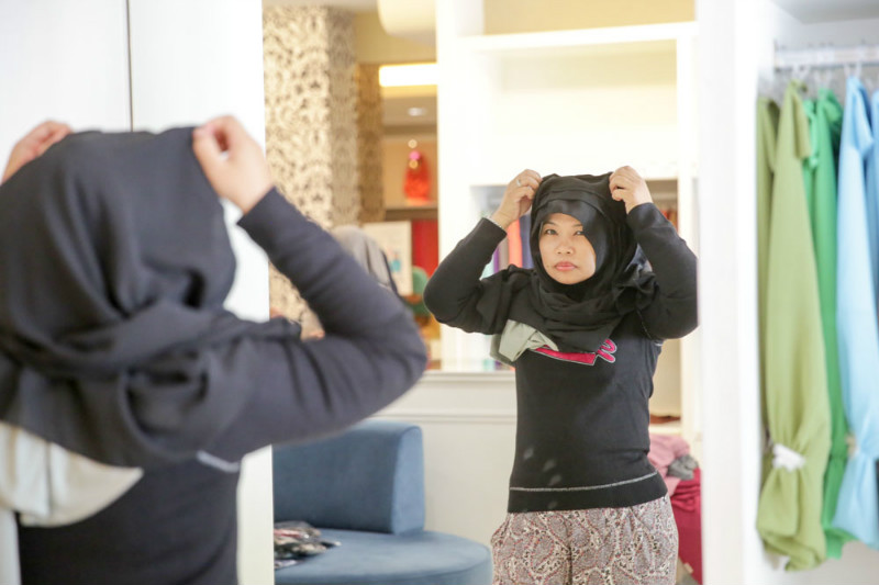 A customer tries on a hijab at the Naelofar Taman Tun Dr Ismail store on April 29, 2015.