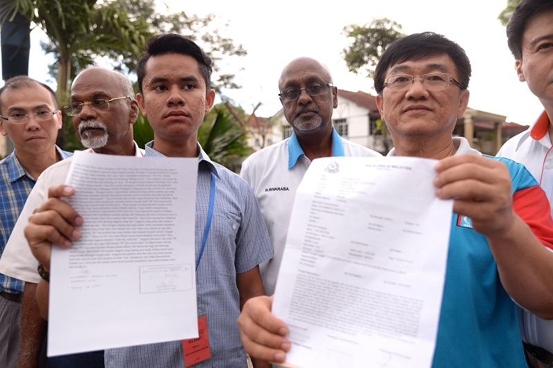 Batu MP Chua Tian Changu00e2u20acu2122s driver Mohd Huraimi Husni (left) and aide Chin Sin Pang (right) show their police report at the Central Seberang Perai District Police headquarters in Penang, May 3, 2015. u00e2u20acu2022 Picture by K.E. Ooi