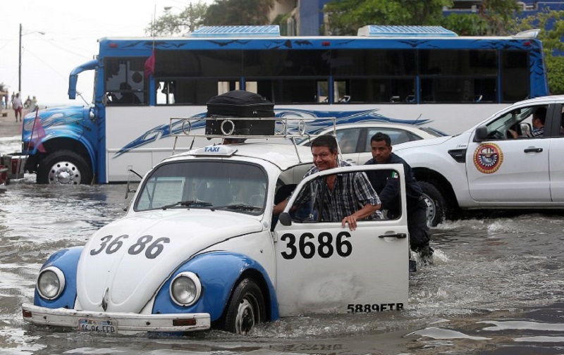 Residents push a taxi along a flooded street in Acapulco, Guerrero state, Mexico, May 3, 2015. u00e2u20acu2022 Reuters pic