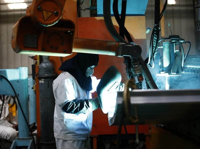 An employee works on a production line of parts for a high speed train at China CNR's Tangshan factory in Hebei province, February 11, 2015. China's April PMI came in at 50.1. u00e2u20acu201d Reuters pic